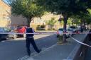 Police behind a cordon at the junction of Rushmore Road and Glyn Road