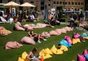 People enjoy the warm weather in Granary Square, London.