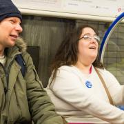 Passengers with badges saying 'please offer me a seat'