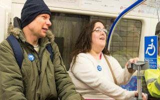 Passengers with badges saying 'please offer me a seat'